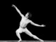 Rudolf Nureyev a torso nudo e calzamaglia bianca danza in una posa scultorea su sfondo nero