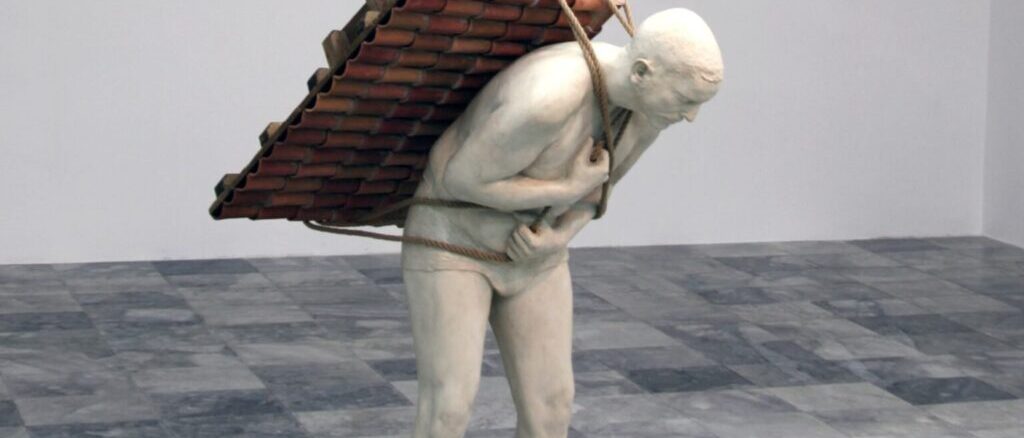 Scultura di un uomo nudo curvato in avanti che trasporta sulla schiena un tetto di tegole legato con corde.