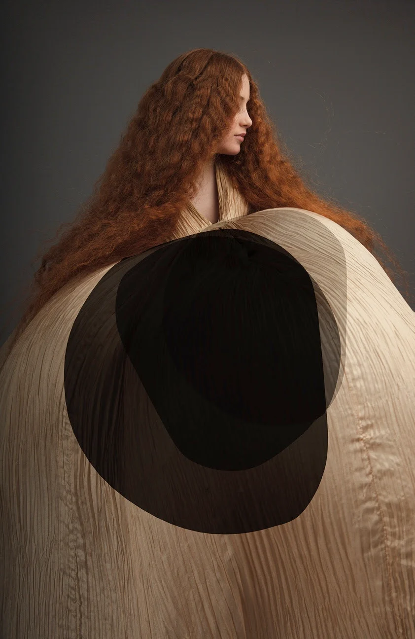 Ritratto d'arte digitale di una donna con lunghi capelli rossi avvolta in una scultura tessile sferica con sovrapposizioni geometriche scure.
